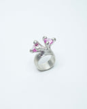 Silver ring with pink gemstones on a white background