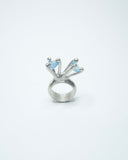 Silver ring with blue gemstones on a white background